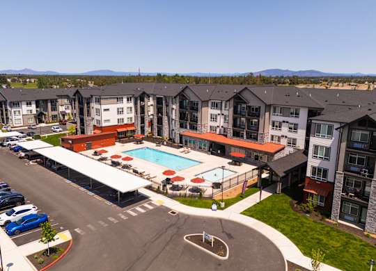 A large apartment complex with a pool and parking lot.