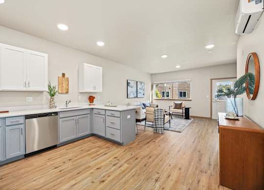 A kitchen with wooden floors and white cabinets.