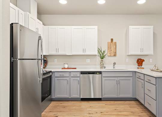 A kitchen with white cabinets and a wooden cutting board on the wall.
