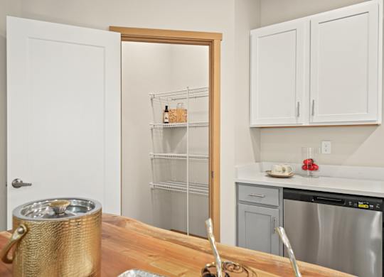 A kitchen with a white door, a white fridge, and a white counter.