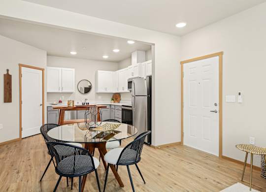 A kitchen with a dining table and chairs.
