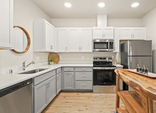 A modern kitchen with wooden countertops and stainless steel appliances.