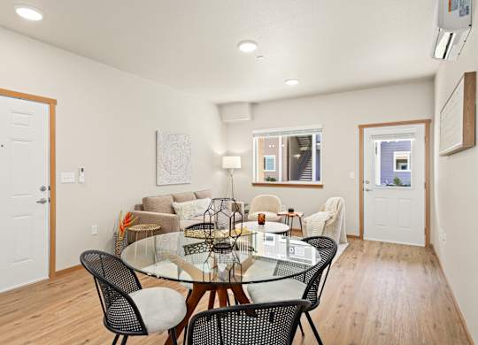 A dining room with a glass table and chairs.