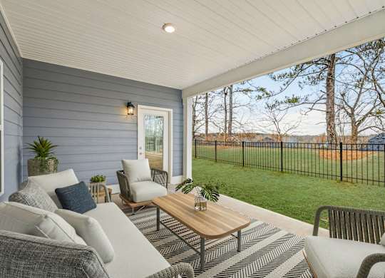 A patio with a sofa, chairs, and a coffee table.