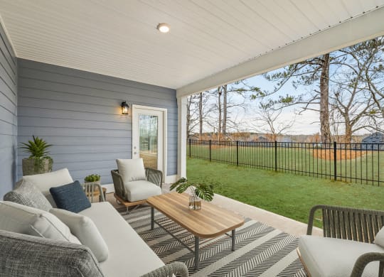 a covered porch with couches and chairs and a table
