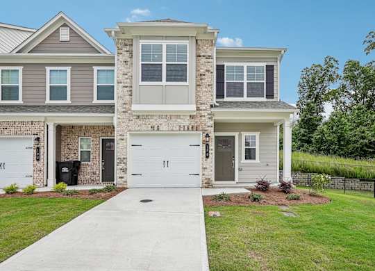 Exterior shot of Waterford layout, two story townhome with a private driveway and attached garage.
