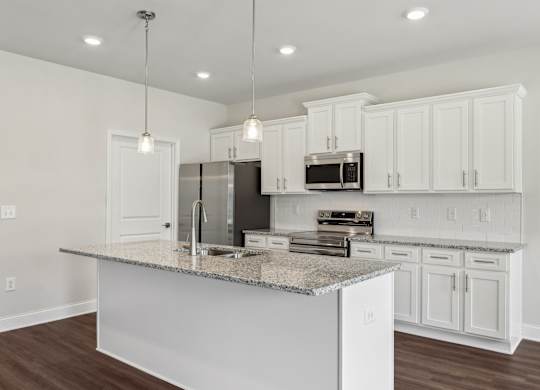 A kitchen with white cabinets and a granite countertop.