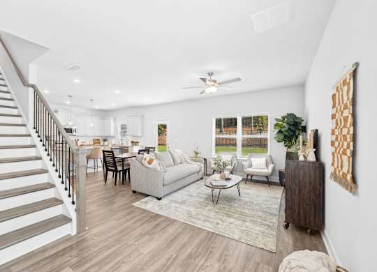 A spacious living room with a staircase on the left side.