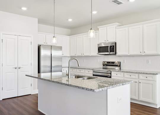 A kitchen with white cabinets and a granite countertop.