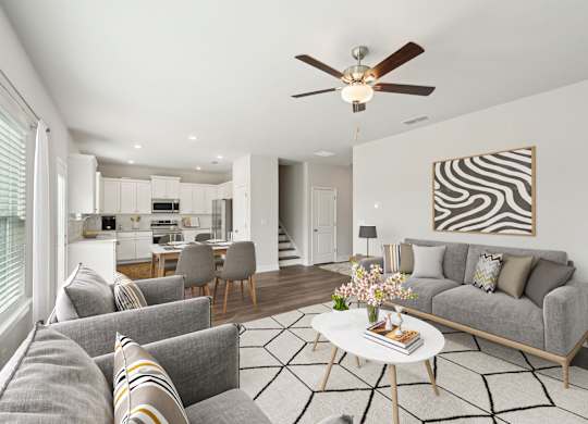 A living room with a grey couch, a coffee table, and a zebra print picture on the wall.