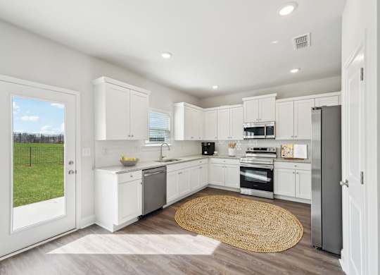 A modern kitchen with white cabinets and stainless steel appliances.