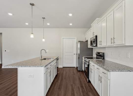 A kitchen with white cabinets and a granite countertop.