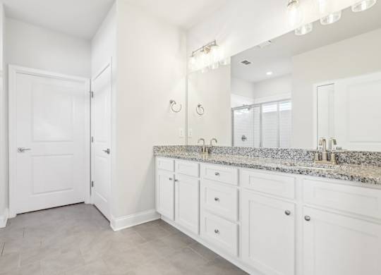 A bathroom with a white vanity and a white door.
