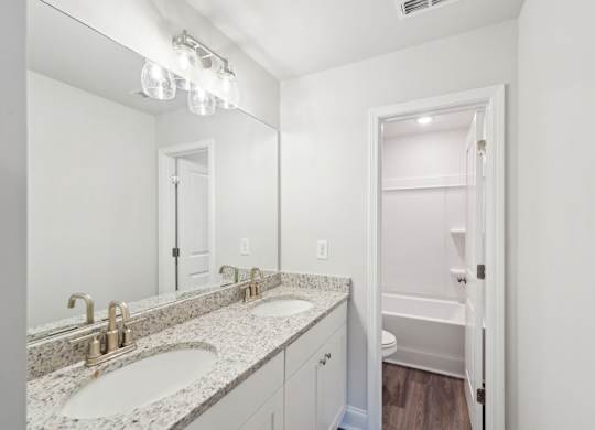 Secondary bathroom with double vanity and tub shower
