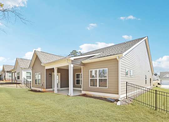 A house with a grey siding and a black fence.