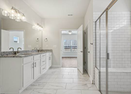 A white bathroom with a walk in shower.