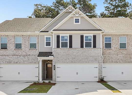 Exterior shot of the Westport floorplan, two story townhome with a private driveway and attached garage.