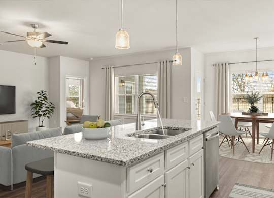 A modern kitchen with a marble countertop and white cabinets.