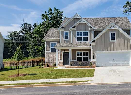 A two-story house with a garage is situated on a street.