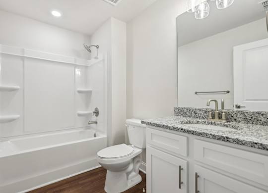 A white bathroom with a toilet, sink, and bathtub.