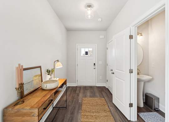 A bathroom with a wooden vanity and white walls.