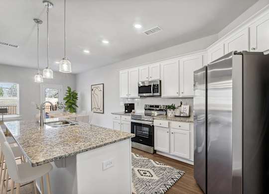 Spacious kitchen with an island, ample storage, stainless steel appliances and view into the backyard.