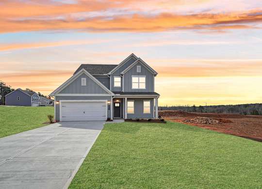 A house with a garage and a driveway in front of it.