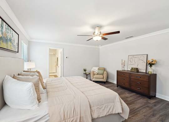 A bedroom with a large bed and a ceiling fan.