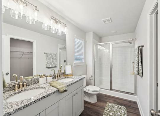 A bathroom with a sink, toilet, and shower.