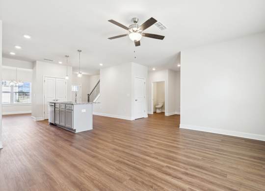 A spacious room with a ceiling fan and wooden flooring.