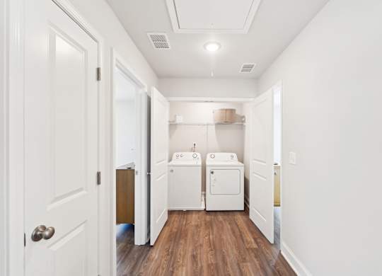 A white laundry room with a washer and dryer.