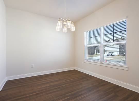 A room with a window and a wooden floor.