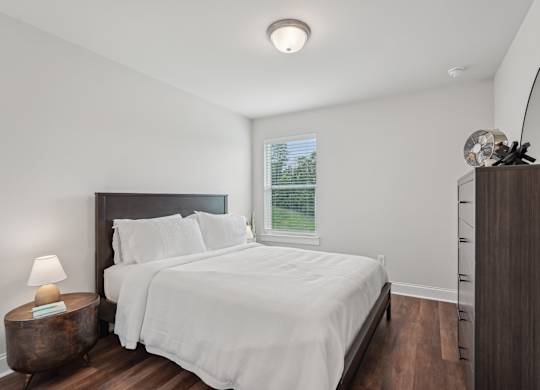 Third bedroom with a queen-size bed and abundant natural light streaming through the window.