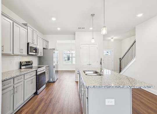 A kitchen with a granite countertop and stainless steel appliances.