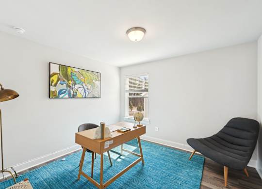 A room with a blue carpet and a wooden chair.