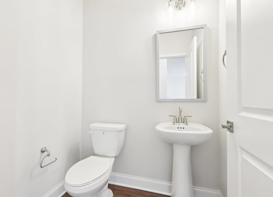 A white toilet and sink in a small bathroom.