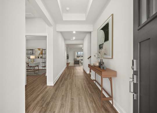A hallway with a wooden floor and a bench.