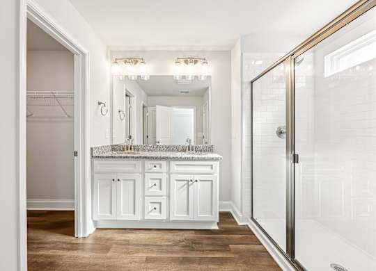 Primary bathroom with double vanity, walk-in shower and walk-in closet.