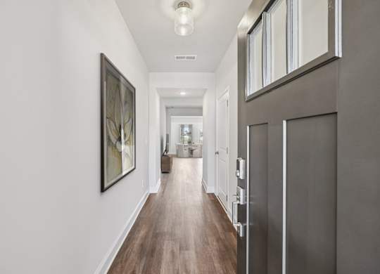 The entrance to the Stafford home featuring rich hardwood-style flooring and crisp white walls.