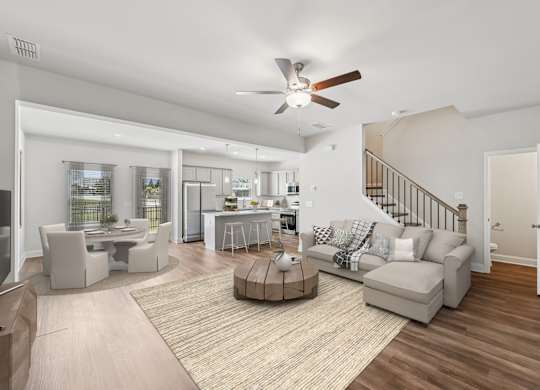 View of the living room area featuring an open staircase and refined dining space.