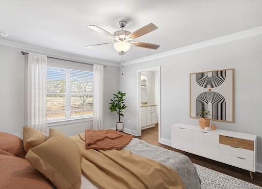 Another view of the spacious primary suite showcasing a grand bed and modern ceiling fan.