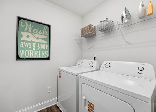 A spacious laundry room complete with full-size washer and dryer.