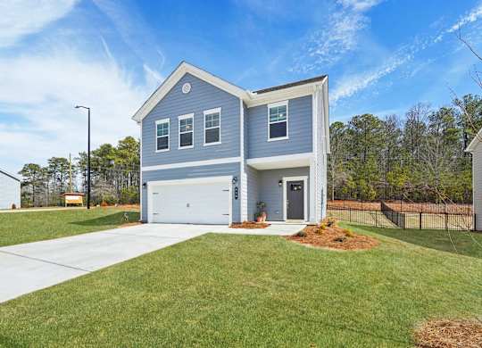 A blue house with a white garage door and a grey roof.