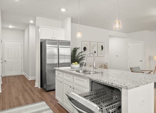 a kitchen with a island and a stainless steel refrigerator