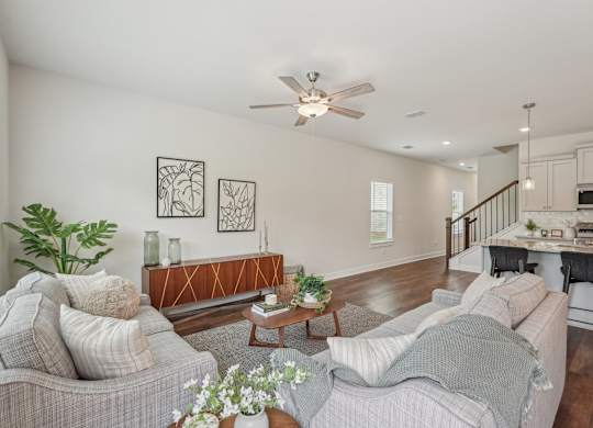 View of the living room area featuring an open staircase and refined dining space.