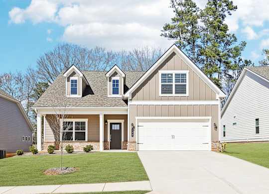 A two-story house with a garage and a driveway.