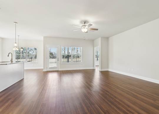 A room with a ceiling fan and a wooden floor.