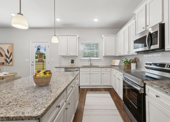 4-bedroom single family home with spacious kitchen. Open-floor plan concept with kitchen island, ample storage and bar seating.