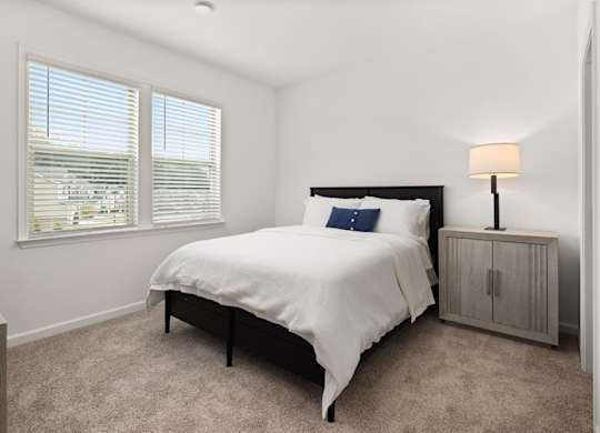 Secondary bedroom with queen size bed and large window letting in a ton of natural light.