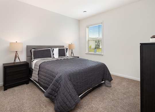 Third bedroom with a queen-size bed and abundant natural light streaming through the window.